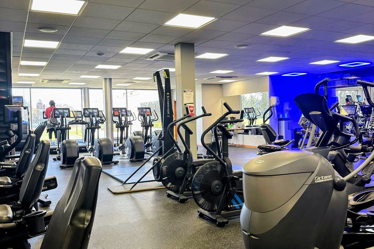 Cleaner disinfecting exercise equipment in a fitness center in Northern Virginia